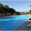 Piscina all'aperto circondata da lettini e ombrelloni.