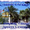 Ingresso di un camping con palme e insegna 