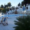 Piscina con sdraio e ombrelloni.