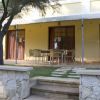 Patio di una casa con tavolo, sedie e asciugamani appesi.