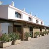Edificio bianco con piante in vaso e patio.