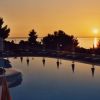 Piscina al tramonto con vista sul mare.