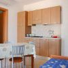 Cucina con tavolo da pranzo, sedie, mobili in legno e divano blu.