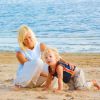 Una donna e un bambino giocano sulla spiaggia vicino al mare.
