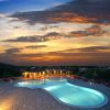 Una piscina illuminata al tramonto con cielo arancione e rosso.