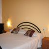 Stanza con letto matrimoniale, cuscini decorativi e comodini.