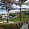 Scalinata in legno che scende verso una spiaggia, con vista sulla costa.