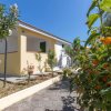 Edificio giallo con giardino fiorito e vialetto.
