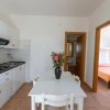 Cucina bianca con tavolo e fiori.