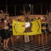 Gruppo in costume tradizionale con bandiera di un'aquila su sfondo giallo.